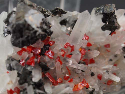 cristalls de quars (cristall de quars de 1,5cm) amb cristalls de realgar i cristalls d'esfalerita (cristall d'esfalerita de 1cm).<br>Mida 3cm x 7cm x 3cm