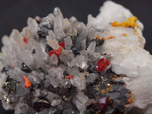 Cristales de cuarzo con cristales de realgar y cristales de esfalerita con algo de orpimente.<br>Medidas 6cm x 5,5cm x 2cm